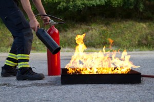 Инструктор демонстрирует, как потушить огонь с помощью огнетушителя